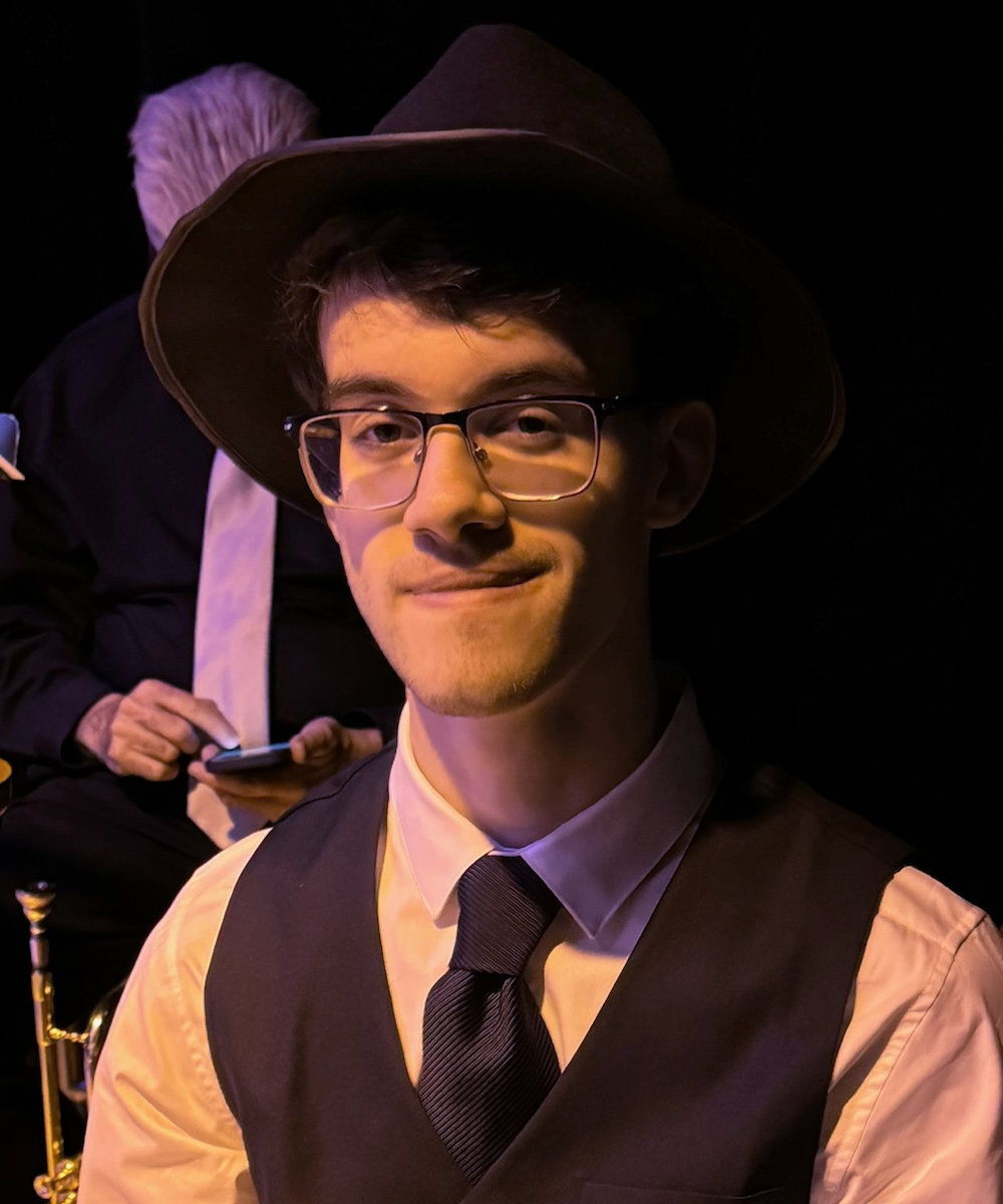 Ryan Polizzi in a shirt, tie and vest and wearing a hat